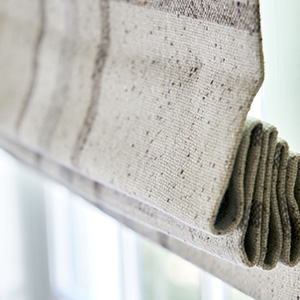 A Flat Roman Shade made of Aberdeen in Oat with blackout lining blocks light which is ideal for bedroom window treatment ideas
